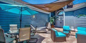 Une terrasse avec des meubles d’extérieur, une décoration en forme d’étoile de mer et une plante en pot.