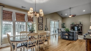 A spacious dining area with a wooden table and chairs, a chandelier, and a ceiling fan. - A Spacious 3 Bdrm Oasis at North Beach Resort (North Myrtle Beach)
