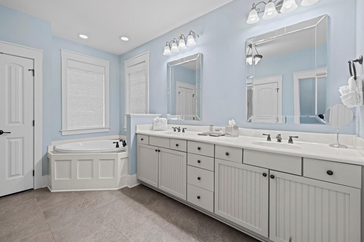 Un baño con tocador doble, un espejo grande e iluminación empotrada.