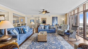 A spacious living room with a blue sofa, a coffee table, and a rocking chair. - A Luxurious 5-Bedroom, 4.5-Bathroom Retreat for 14 (North Myrtle Beach)