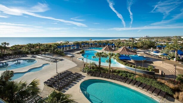 A resort with multiple swimming pools, lounge areas, and a view of the ocean. - Modern 1 Bedroom Luxury Flat Your Stylish Oasis (North Myrtle Beach)