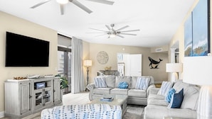 A living room with a sofa set, a flat-screen TV, a ceiling fan, and a dining area. - Elegance and Comfort Await: a Perfect Retreat (North Myrtle Beach)