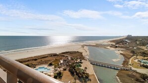 A coastal resort with a beach, a swimming pool, and a bridge connecting the property to the beach. - Elegance and Comfort Unite: A Cozy Getaway for 10 (North Myrtle Beach)