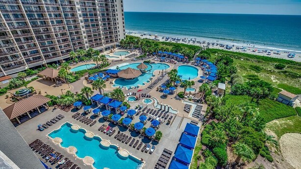 A resort with multiple swimming pools, sun loungers, and a beach view. - Unwind in Luxury : Oceanfront 4 Bedroom Condo (North Myrtle Beach)