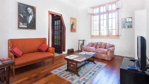 Una sala de estar con dos sofás, una mesa de centro y un televisor.
