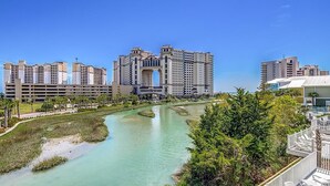 A modern hotel with a central courtyard, a river, and surrounding greenery.