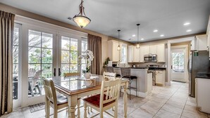 A spacious kitchen with a dining area, large windows, and a view of the outdoors. - Discover Serenity and Elegance in This 3BR/3.5BA (North Myrtle Beach)