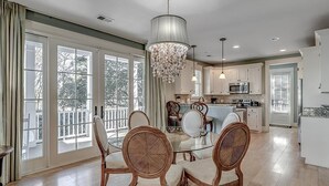 A spacious kitchen with white cabinets, a central island, and a chandelier. - Unwind in Style: Luxurious 4BR/4.5BA Vacation Home (North Myrtle Beach)
