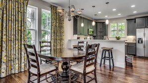A modern kitchen with dark cabinets, a stainless steel refrigerator, and a central island.