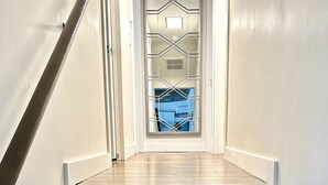 A wooden staircase with white walls and a metal railing. - Orlando Vacation Rental Heated Pool & Spa 5 BR 3 BA Near Space, Nature, Disney  (Titusville)