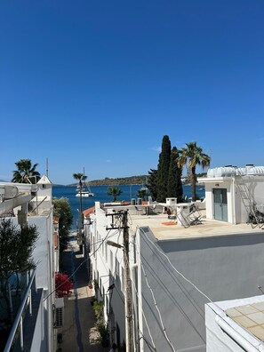 A narrow street with buildings on either side, leading to a view of the sea. - Tiana Butik Otel (Bodrum)