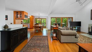 A spacious living area with a dining table, sofa, and television.