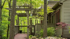 A wooden deck leading to a building surrounded by trees.