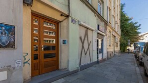 Una calle con un edificio que tiene una puerta de madera y un toldo cerrado.