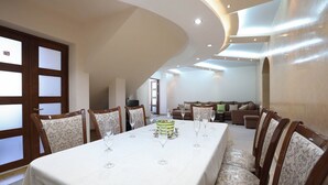 Un espace repas avec une longue table, des chaises et un gâteau décoratif au centre.
