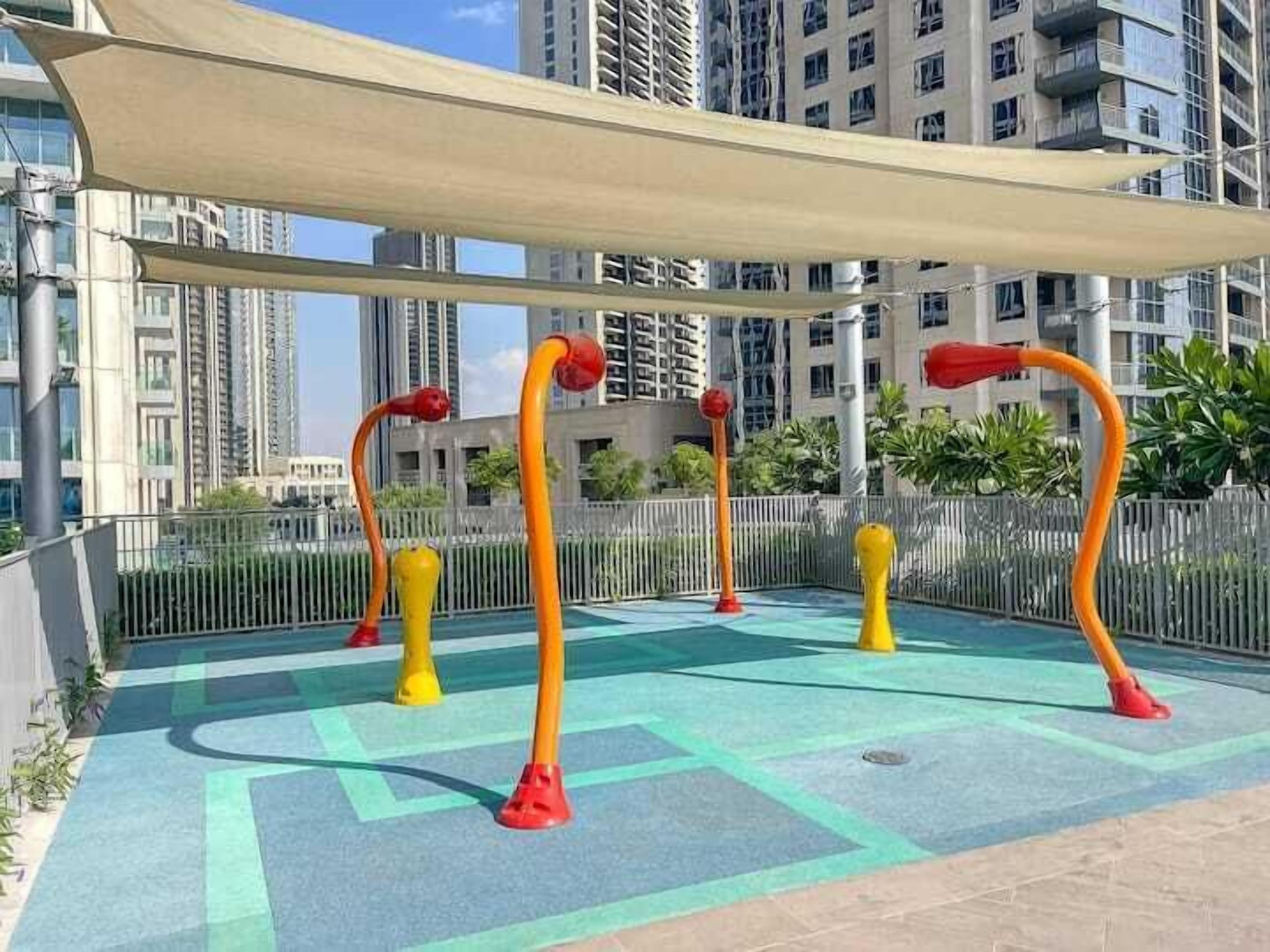 An outdoor play area with colorful equipment and a shaded seating area.
