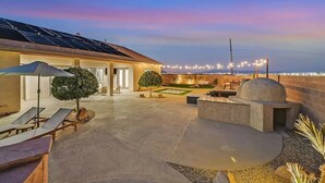 A rooftop patio with lounge chairs, a barbecue grill, and a view of the city skyline. - Lux 5BR Villa w Pool, Spa, RV Parking, Sleeps 12 (Henderson)