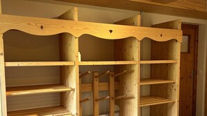 Een houten kamer met ingebouwde planken en een ladder.