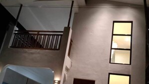 Ein zweistöckiges Gebäude mit Balkon, großem Fenster und einer Tür.
