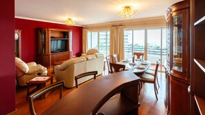 Un salón amplio con un sofá grande, una mesa de comedor y una televisión.
