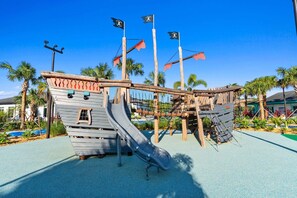 A playground with a pirate ship theme, including a slide and climbing structures.