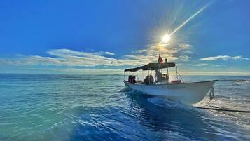 A boat with passengers on a calm sea under a clear sky.