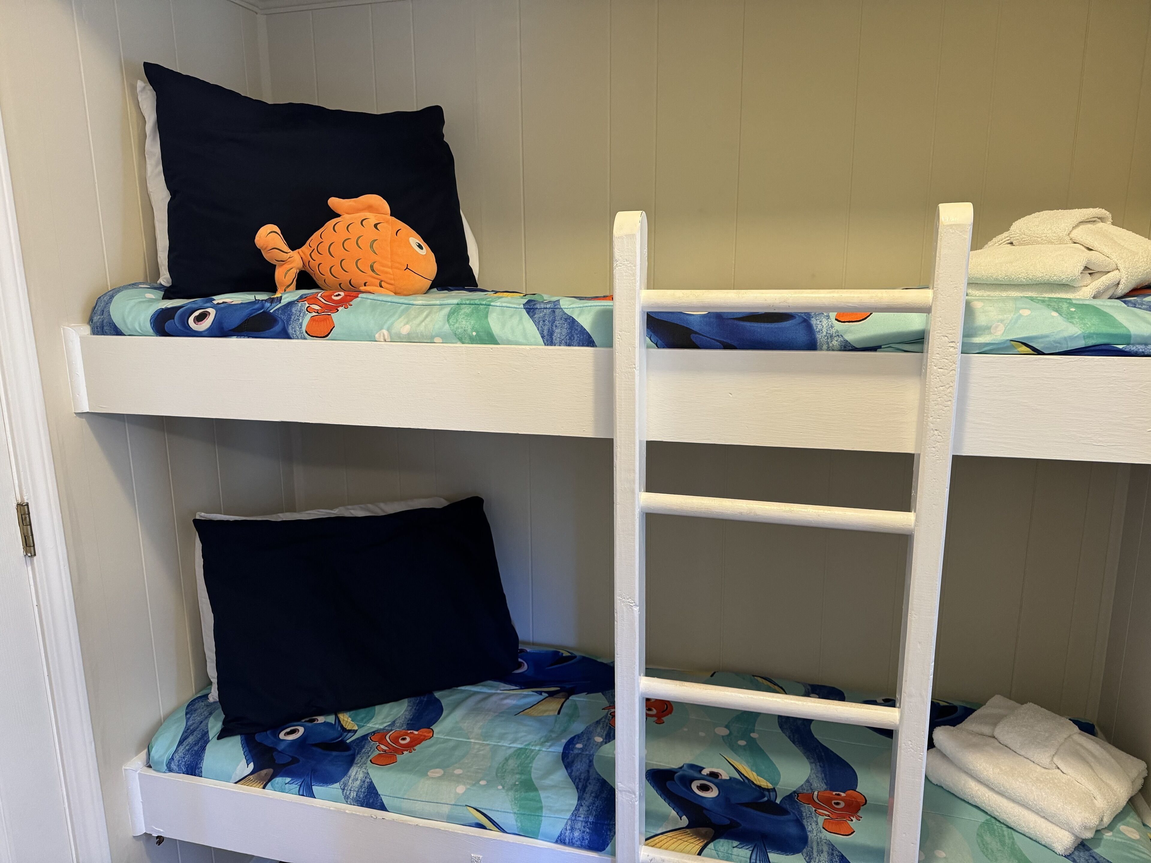 Una cama litera con dos niveles, cada uno con almohada y manta.