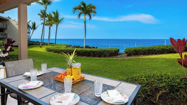 Ein Tisch im Freien mit Blick auf das Meer und Palmen.