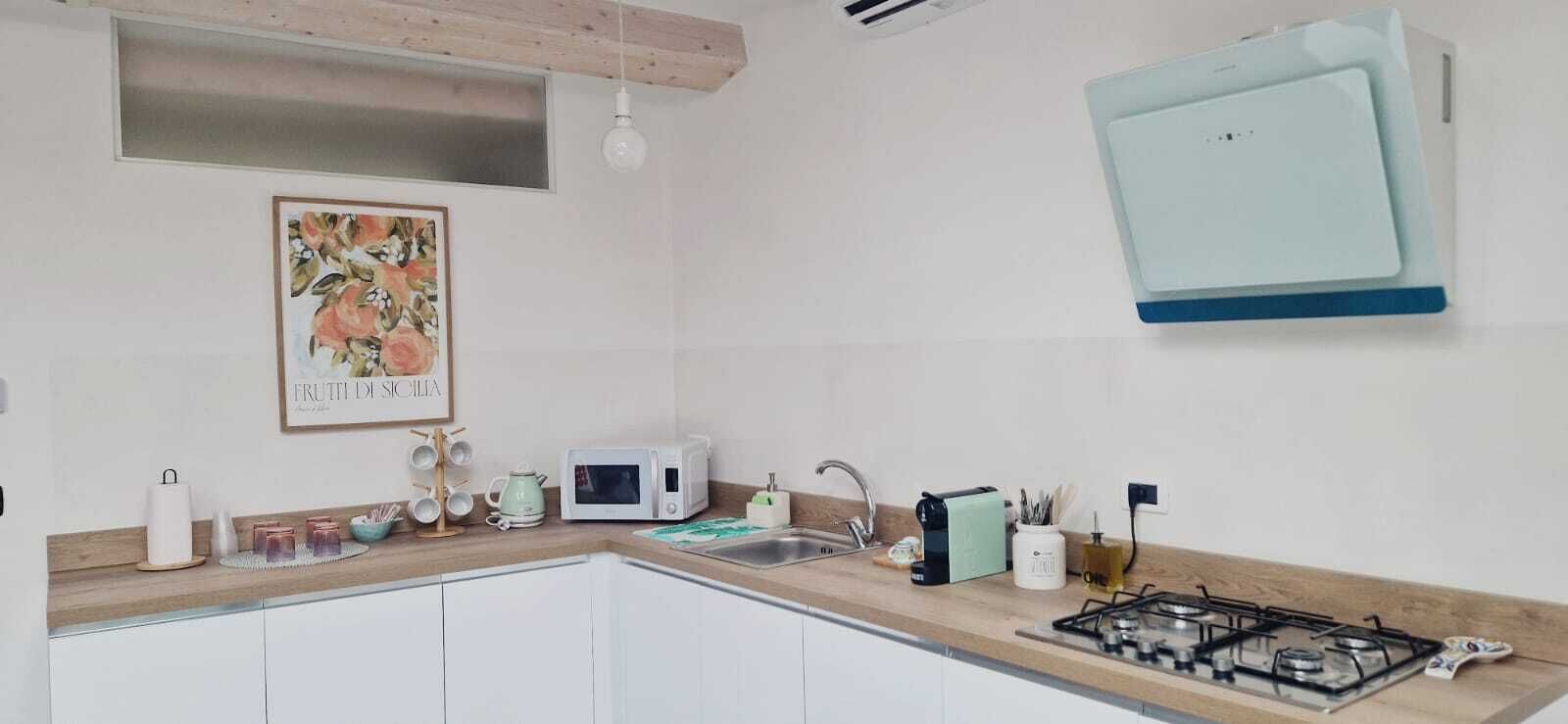 A kitchen with white cabinets, a microwave, a gas stove, and a hanging light fixture.