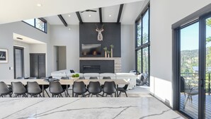 Een moderne keuken met een groot eiland, een open haard en uitzicht op de omgeving.