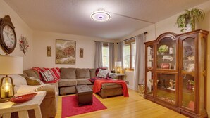 A living room with a sofa, ottoman, and a cabinet with glass doors. - Harmony Home w/ Fire Pit: 5 Mi to Niagara Cave! (Harmony)