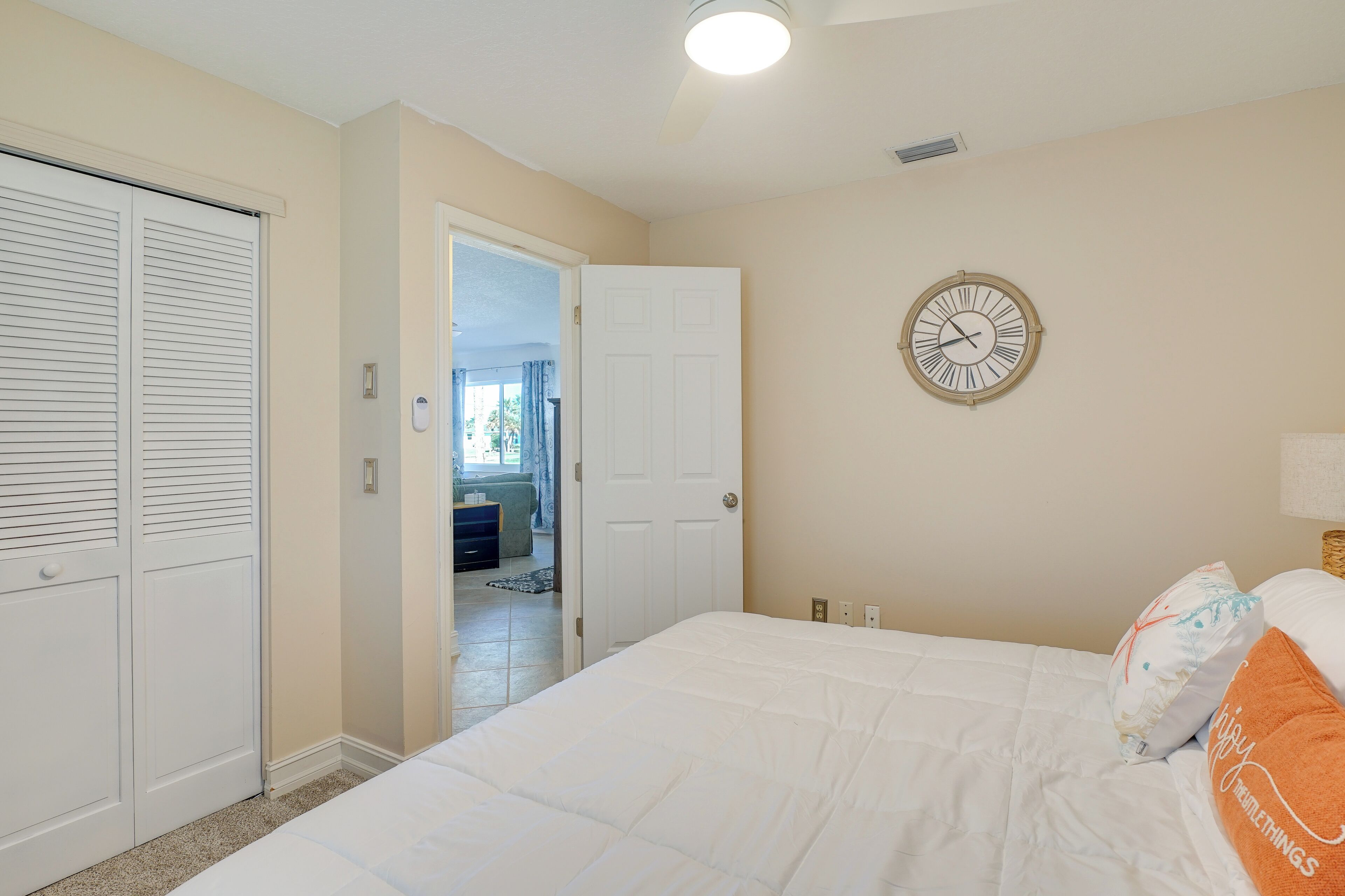 Une chambre à coucher avec un lit, une horloge et une armoire.