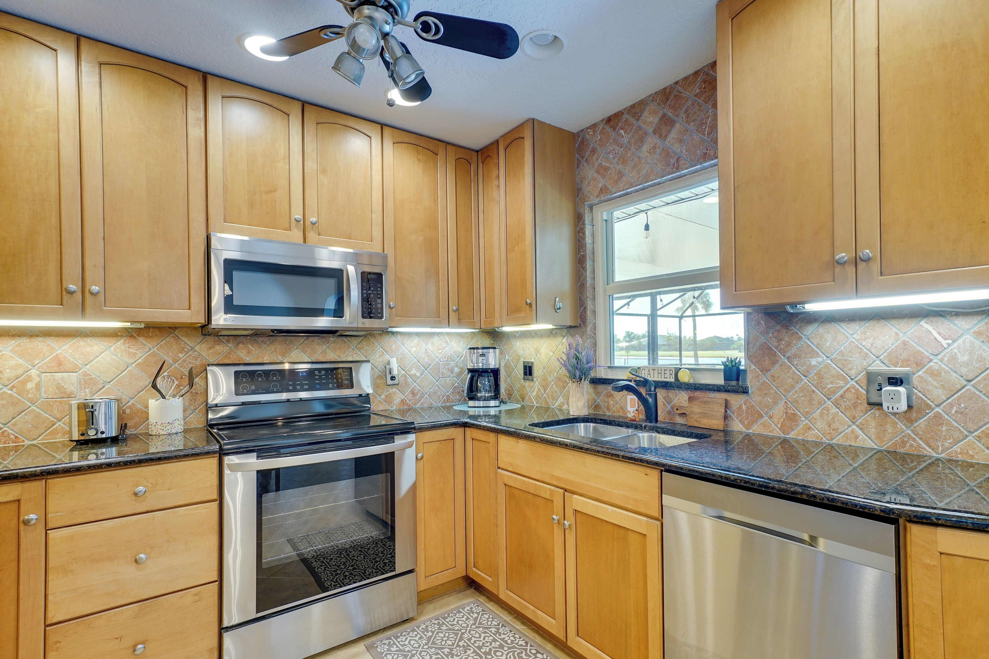 A kitchen with wooden cabinets, stainless steel appliances, a microwave, oven, and a dishwasher.
