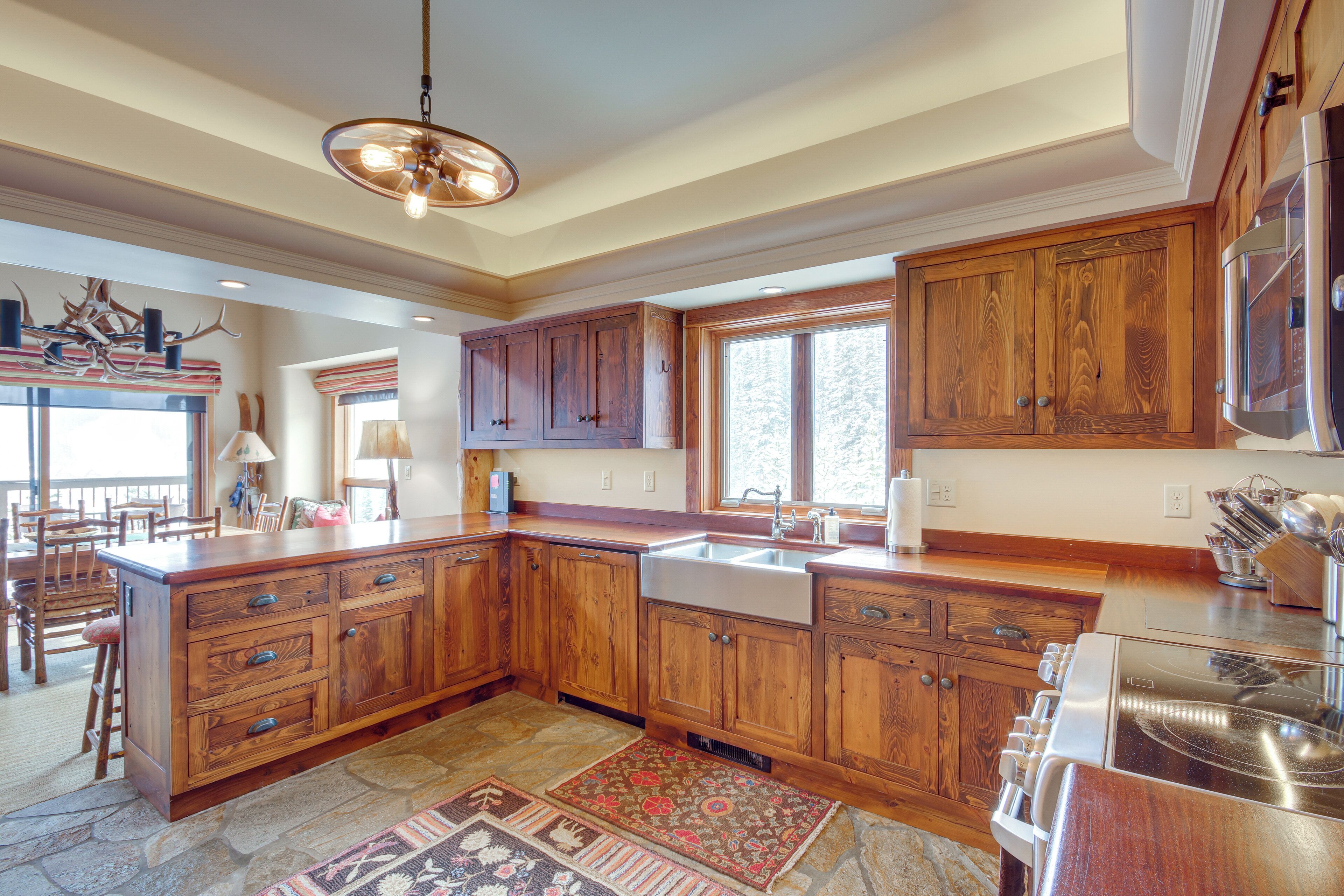 A spacious kitchen with wooden cabinets, a large island, and a stainless steel stove.