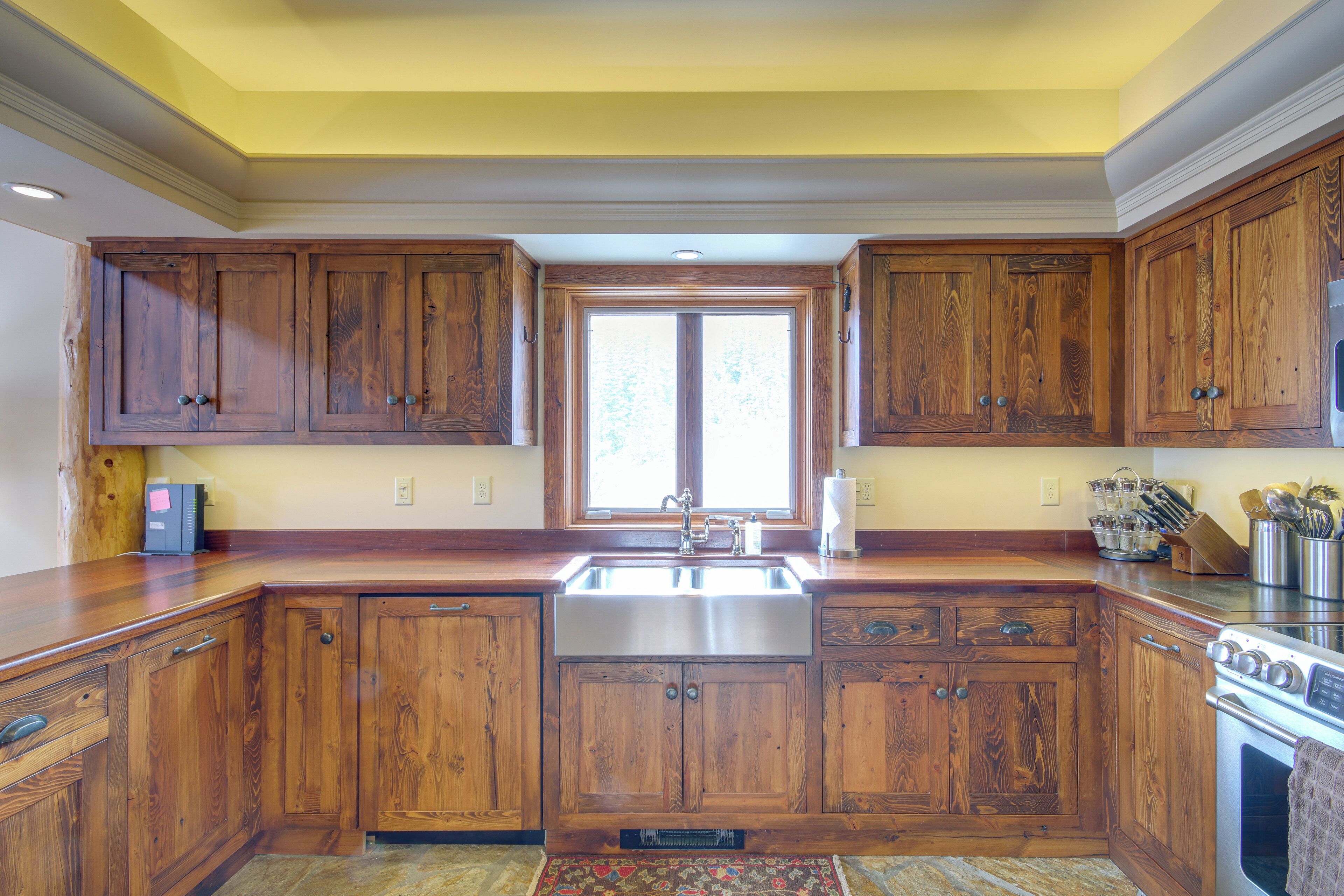 Una cocina con armarios de madera, un lavamanos de acero inoxidable y un horno empotrado.
