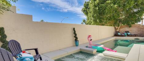 Ein Schwimmbecken mit Liegestühlen und einem Flamingo-Schwimmreifen.