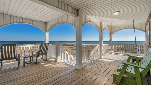 A wooden deck with a view of the ocean, featuring a covered seating area with chairs and a bench. - Alpha At The Point: Oceanfront, Private Pool & Hot Tub, Breathtaking Views (Garden City Beach)