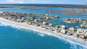 An aerial view of a coastal residential area with houses, a beach, and a marina. - Alpha At The Point: Oceanfront, Private Pool & Hot Tub, Breathtaking Views (Garden City Beach)