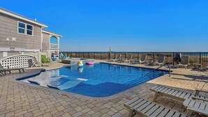 A swimming pool with lounge chairs and a view of the beach. - Alpha At The Point: Oceanfront, Private Pool & Hot Tub, Breathtaking Views (Garden City Beach)