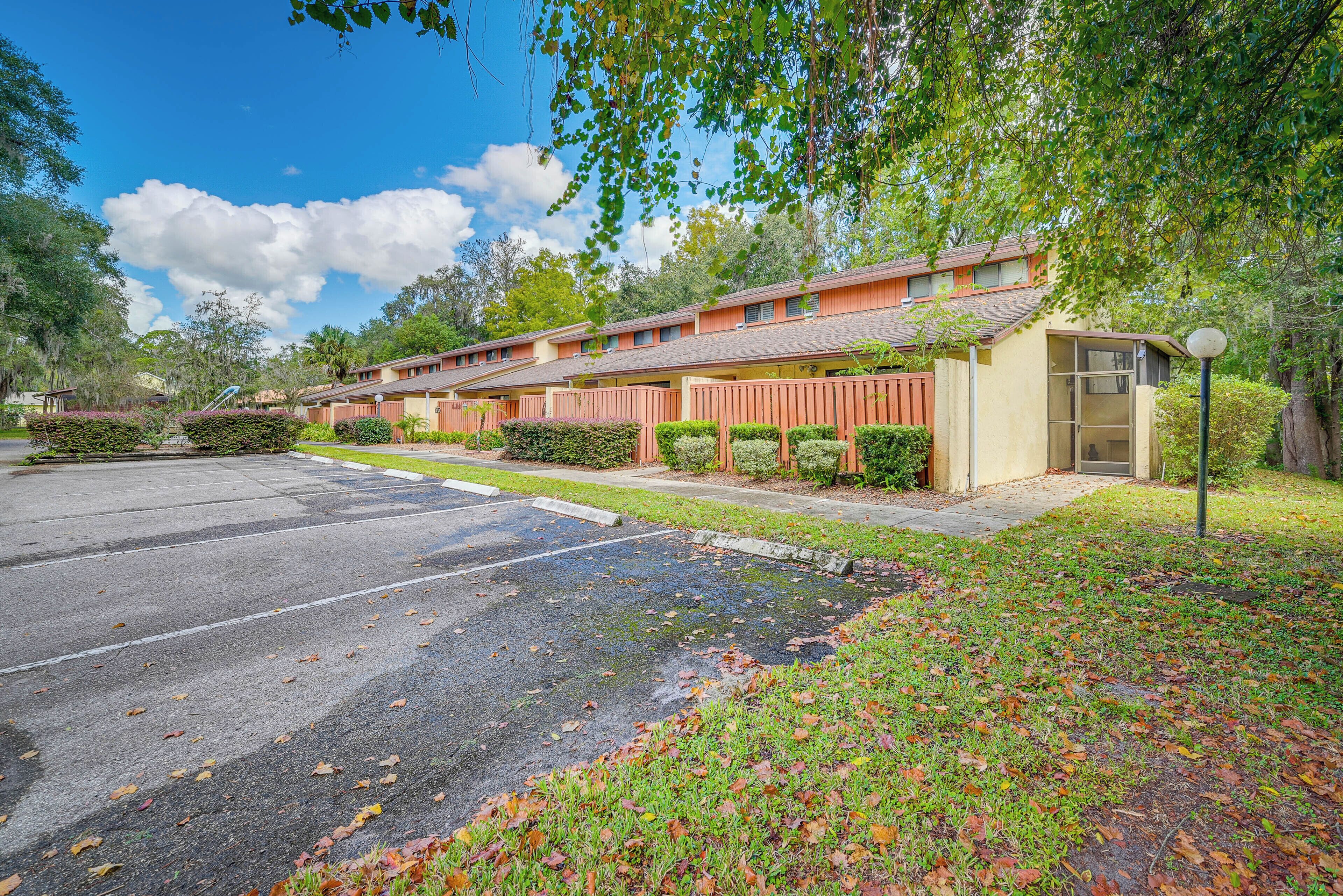 A motel with multiple rooms, a parking lot, and a well-maintained lawn.