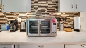 Eine moderne Küche mit einem eingebauten Toaster, einer Kaffeemaschine und einem Wasserkocher.