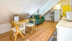 Ein kompakter Wohnbereich mit Essbereich, einem grünen Sofa und einer Küchenzeile.