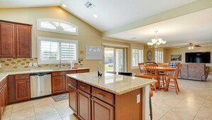 A spacious kitchen with wooden cabinets, a dishwasher, and a granite countertop. - Corona De Tucson Home With Hot Tub! (Vail)
