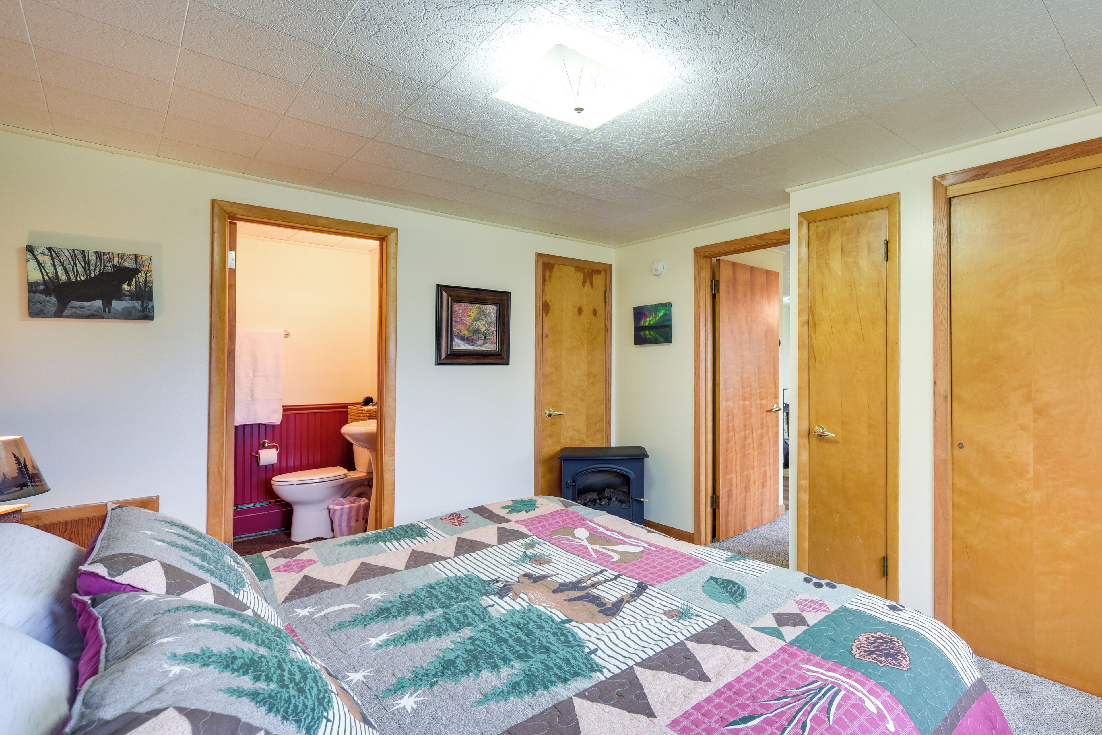 A bedroom with a bed, a fireplace, a toilet, and a door.