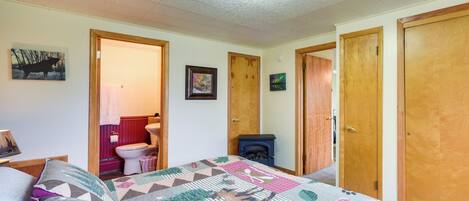 A bedroom with a bed, a fireplace, a toilet, and a door.