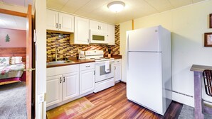 A compact kitchen with white cabinets, a microwave, stove, and refrigerator. - Lake Superior Getaway - Walk to Water! (Duluth)