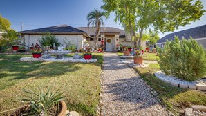 A residential house with a gravel driveway, potted plants, and a well-maintained lawn. - Spacious Bryan Vacation Rental w/ Pool & Patio! (Bryan)