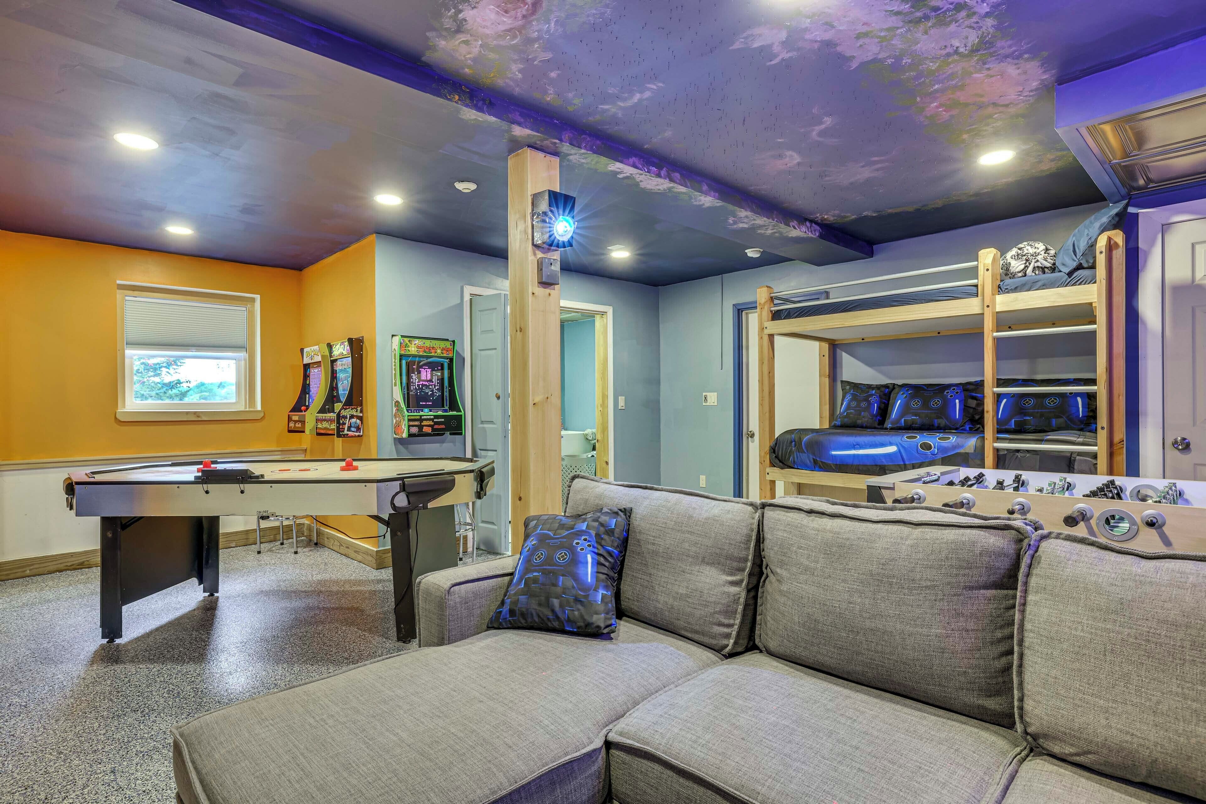 Ein Zimmer mit Poolbillard, einer gepolsterten Couch mit gemustertem Kissen und einem Kicker.
