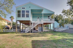 A two-story house with a covered porch and a staircase leading to the upper level. - Sunny Waveland Home Rental w/ Pool: Walk to Beach! (Waveland)