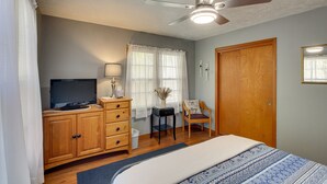 A bedroom with a bed, wooden wardrobe, television, and a ceiling fan. - Missouri Escape w/ Furnished Patio, Near Downtown! (Nevada)